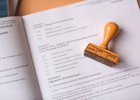 Close-up of a legal document with a wooden stamp placed on top, highlighting verification.